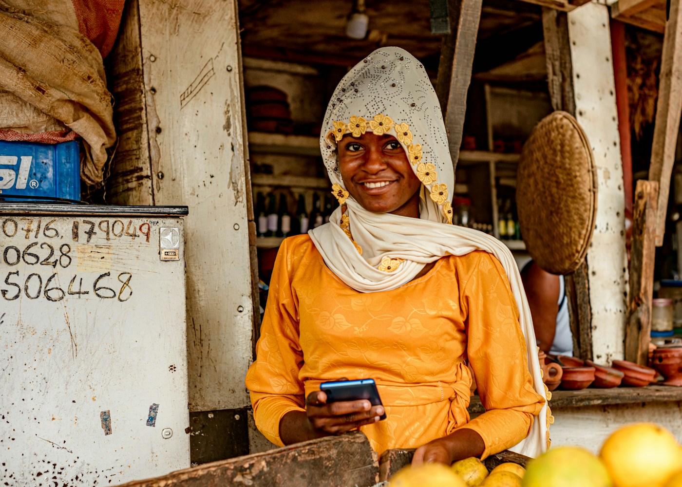 Une vendeuse au marché avec son téléphone